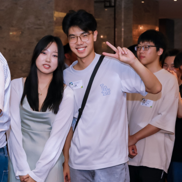 Two UCD alumni at a global event, smiling at the camera.